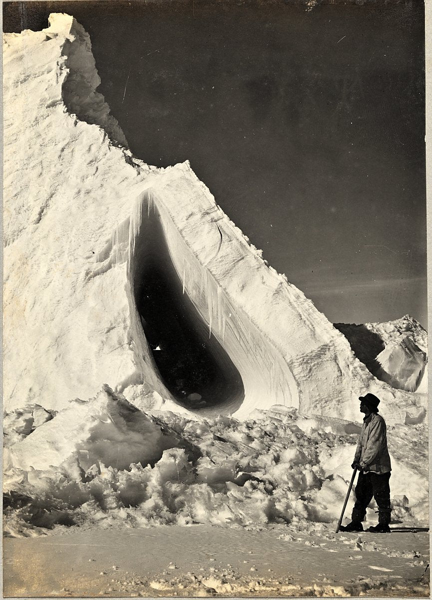 Grotto Berg with Griffith Taylor in the foreground, Cape Evans — photograph, 1911
