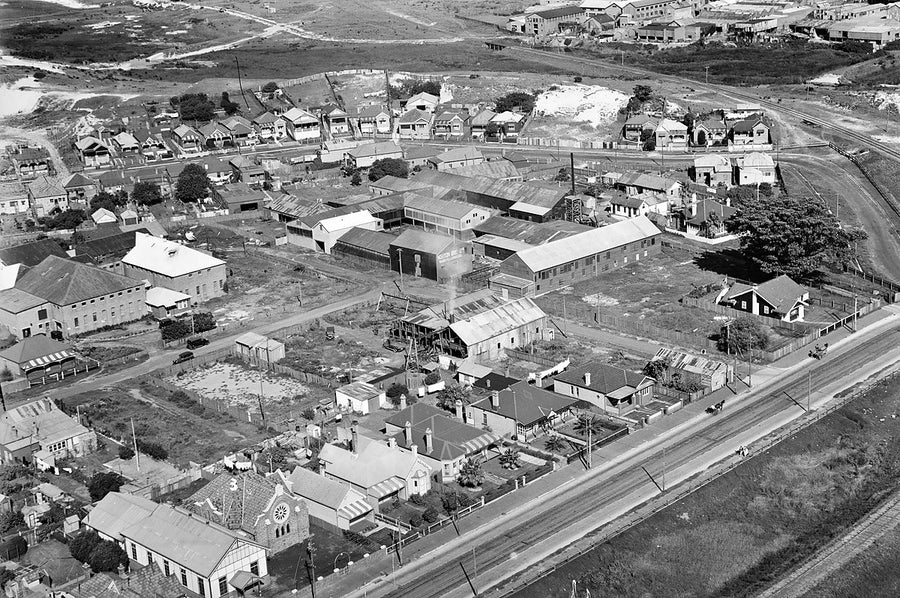 Norton Bros Ltd works among suburban streets and a rail line, from the air — photograph, 1930s