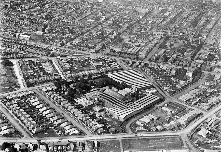 Sawtooth-roofed factory works ringed by terraced streets, inner Sydney — photograph, c. 1937