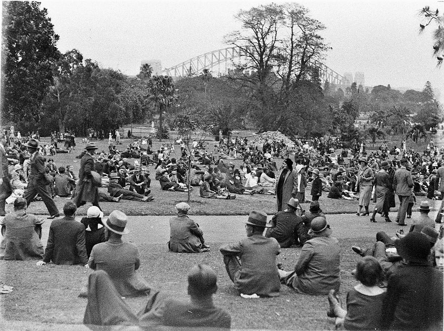Crowds on the Botanic Gardens lawns, Sydney Harbour Bridge beyond — photograph, from Royal Botanic Garden, c. 1930s