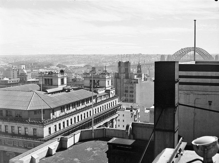 Rooftop view across the Sydney city centre to the Harbour Bridge — photograph, from Mid City Centre, 1951