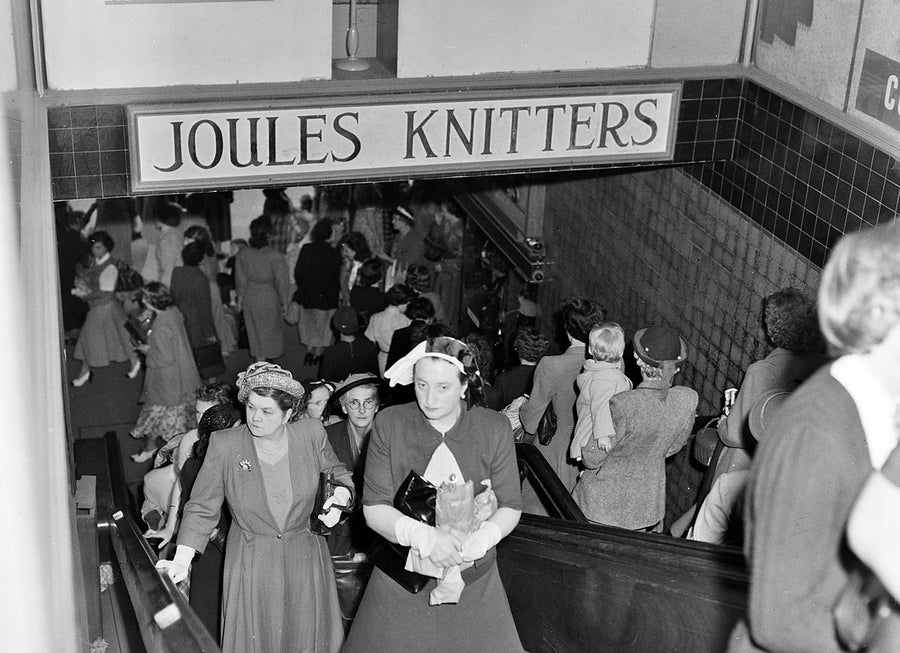 Shoppers descending beneath the Joules Knitters sign, Sydney arcade — photograph, from Sydney, 1950