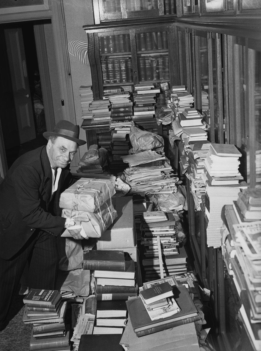 Man amid a book collection at Marrickville, 1949 — photograph, from Marrickville, circa 1949