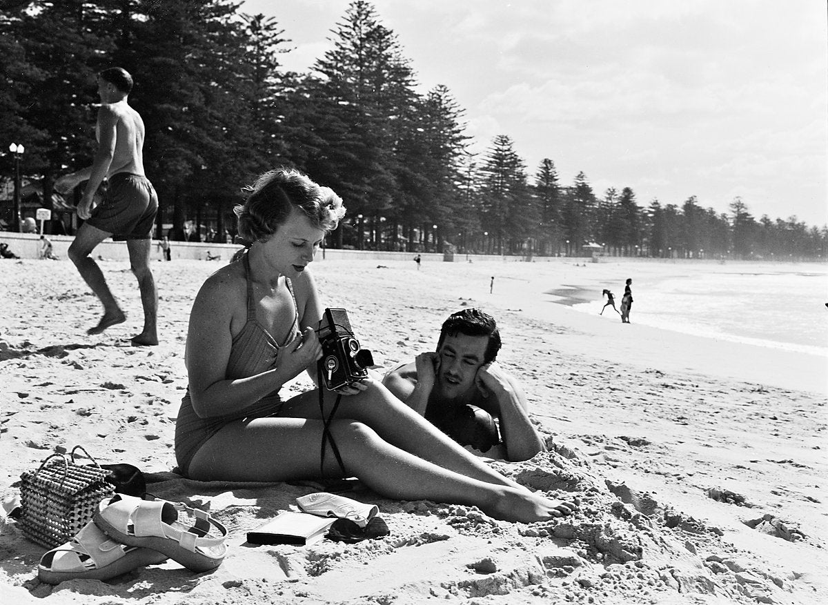 Pam Waddell with a Rolleiflex camera on Manly Beach — photograph, from Manly Beach, circa 1950