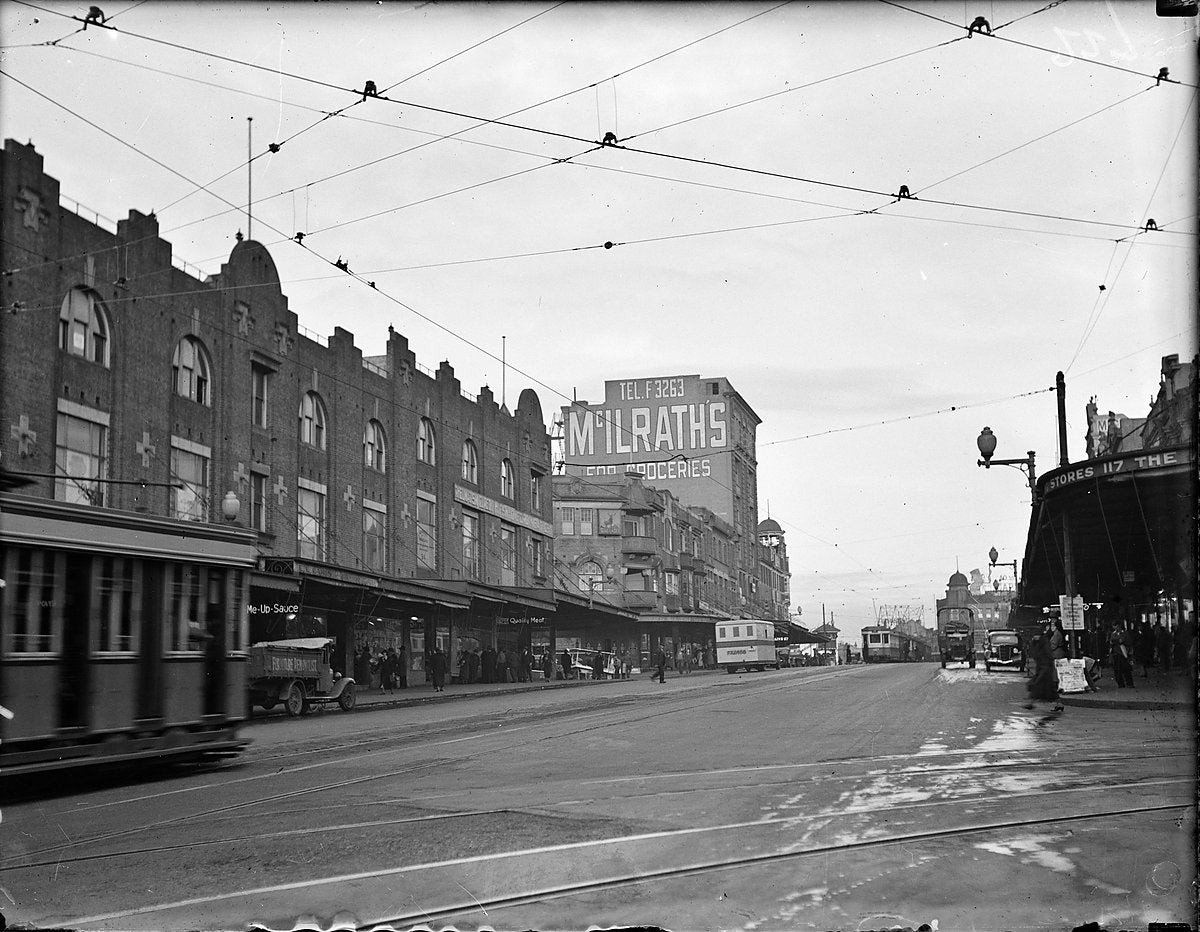 Trams beneath the McIlrath's grocery sign, Sydney — photograph, circa 1934