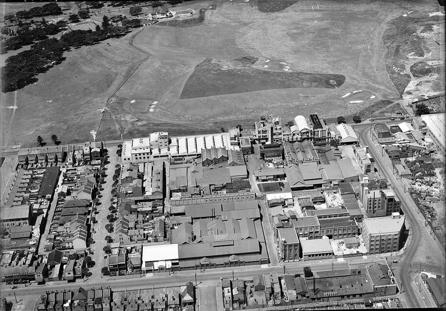 Factories and terraces beside open ground, seen from the air — photograph, circa 1940