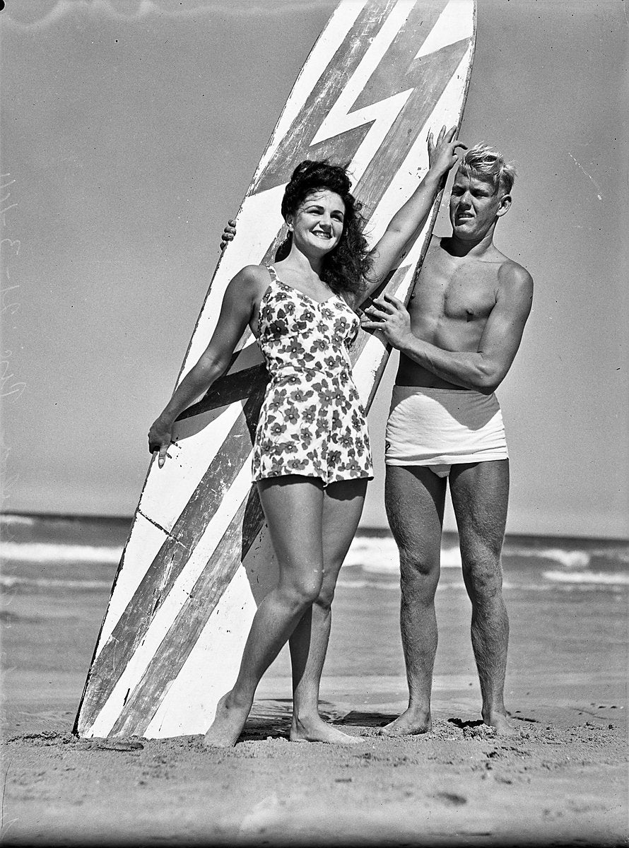 Man and woman with a striped surfboard, Maroubra Beach, 1944 — photograph, from Maroubra Beach, circa 1944