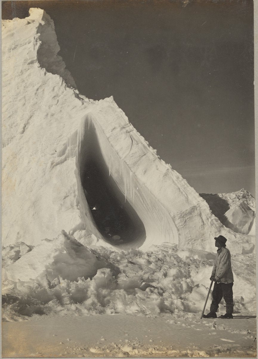 Grotto Berg with Griffith Taylor in the foreground, Cape Evans, January 1911 — photograph, circa 1911