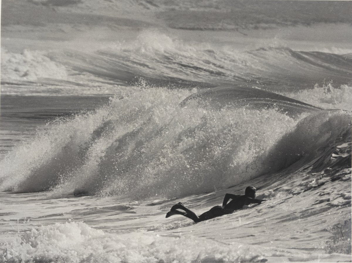 Surfer riding the face of a breaking wave — photograph, circa 1948