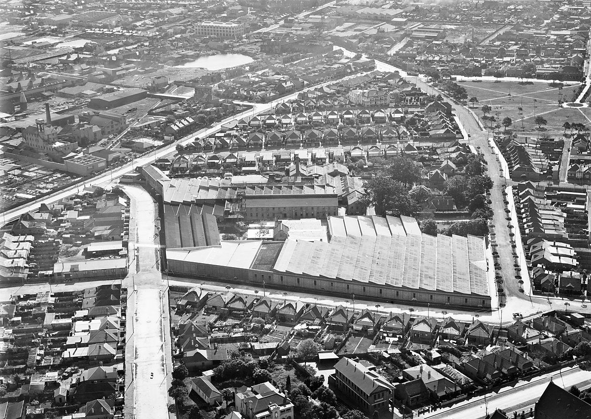 Sawtooth-roofed industrial works and terraces, Sydney — photograph, c. 1937