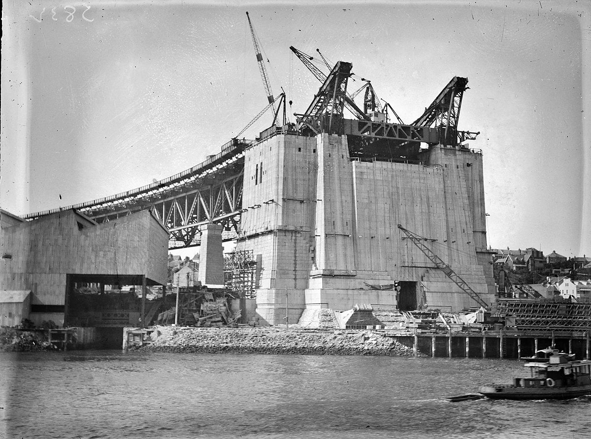 Creeper cranes on a Sydney Harbour Bridge pylon under construction — photograph, from Fitzroy Street, circa 1930