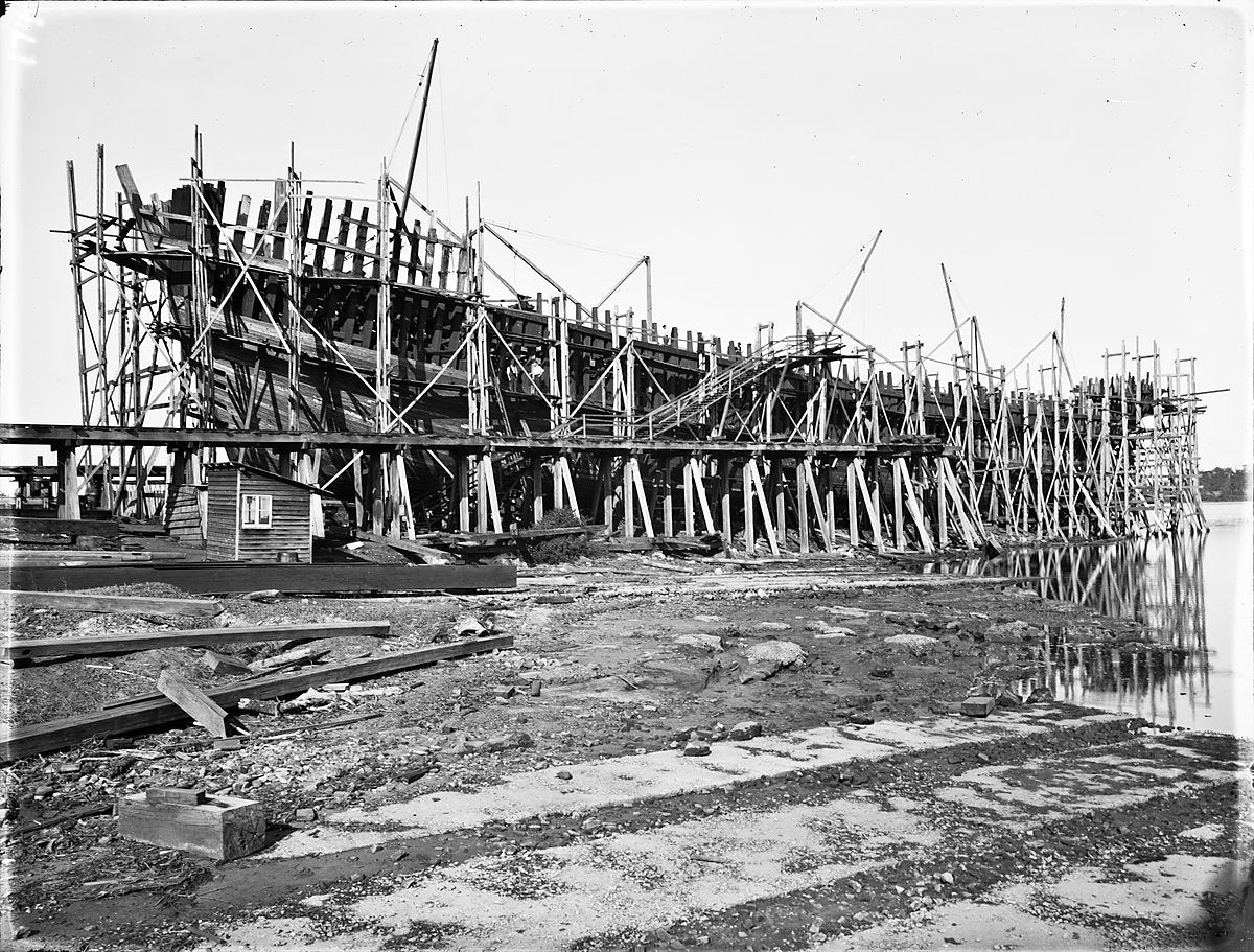 Wooden ship on the stocks, Kidman & Mayoh shipyard, Kissing Point — photograph, from Kissing Point Park, c. 1920–25