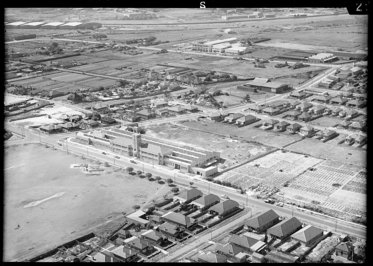 Multi-storey factory among market gardens and housing, Mascot — photograph, from Mascot, circa 1940