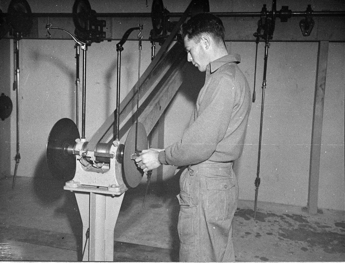 Student at a belt-driven grinding machine, East Sydney Technical College — photograph, from East Sydney Technical College, Darlinghurst, circa 1949