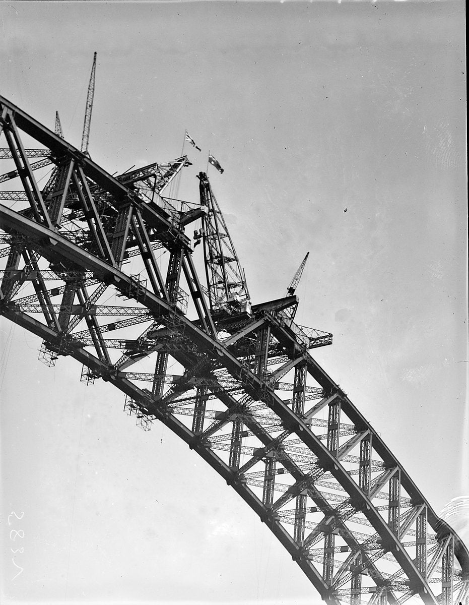 Creeper cranes and flags on the Sydney Harbour Bridge half-arch — photograph, from Glen Street, circa 1928