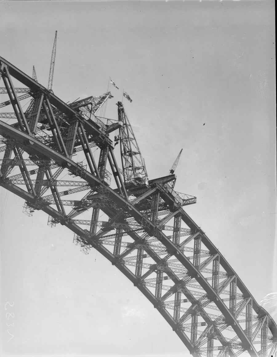 Creeper cranes and flags on the Sydney Harbour Bridge half-arch — photograph, from Glen Street, circa 1928