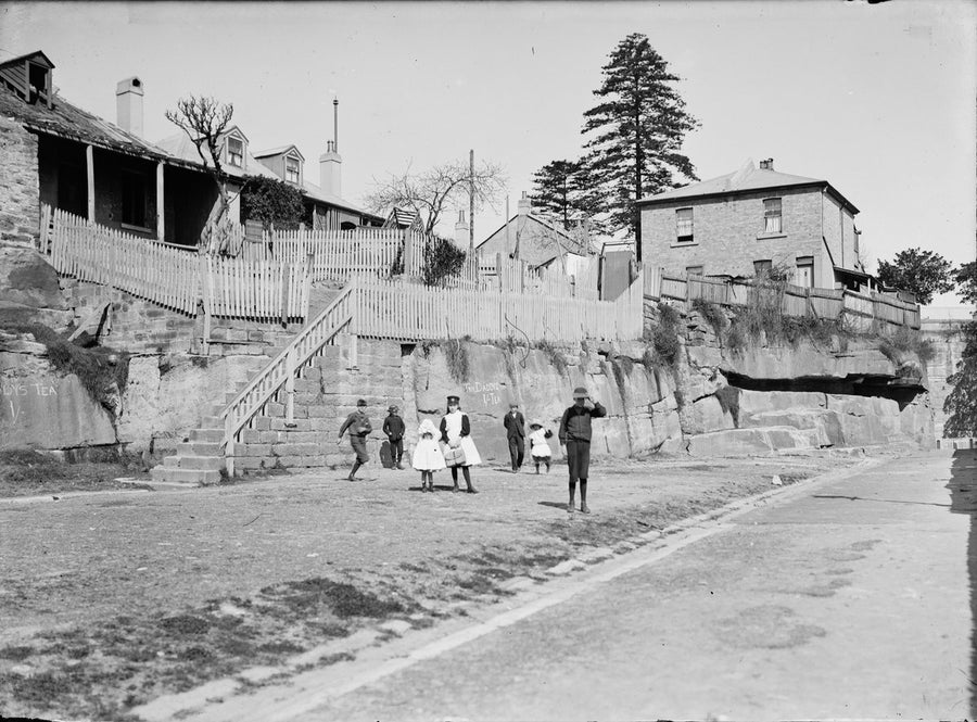 Children beneath the rock-face cottages, The Rocks, Sydney — photograph, from The Rocks, circa 1800