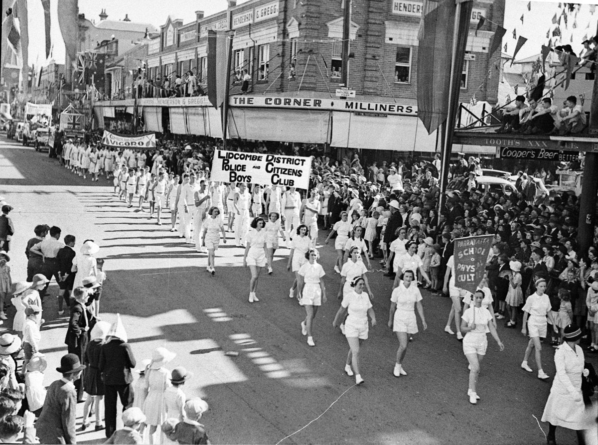 Marching contingents on parade past "The Corner Milliners", Parramatta — photograph, from Parramatta, circa 1938