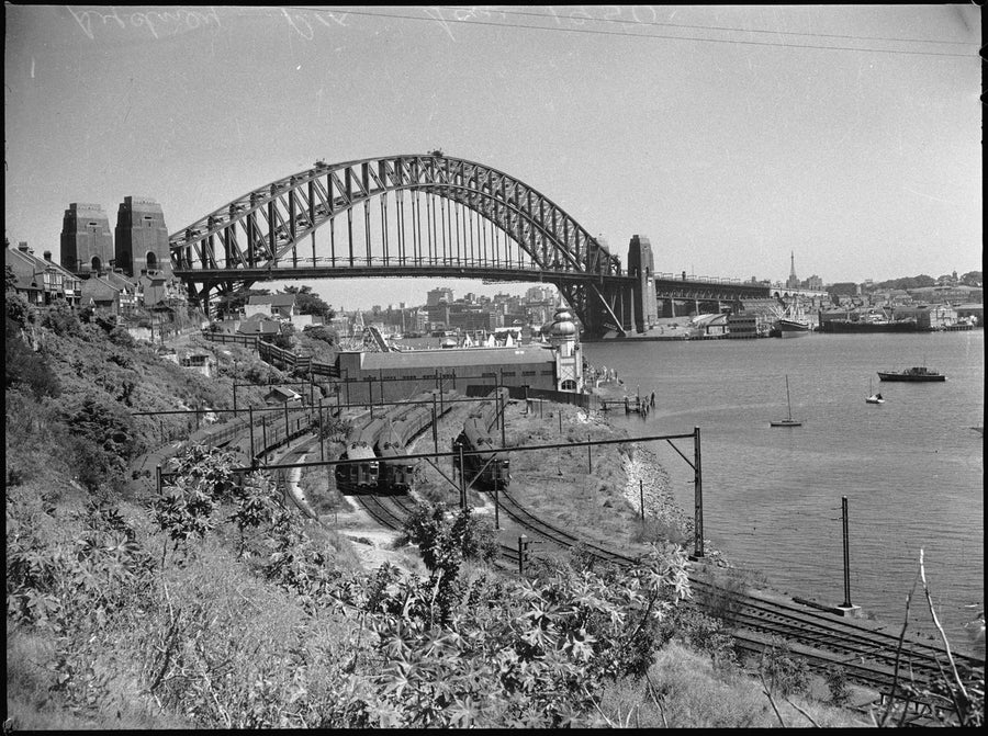 Sydney Harbour Bridge from Lavender Bay, with electric trains in the railway yards — photograph, from Lavender Bay, Sydney, with the Sydney Harbour Bridge, circa 1950