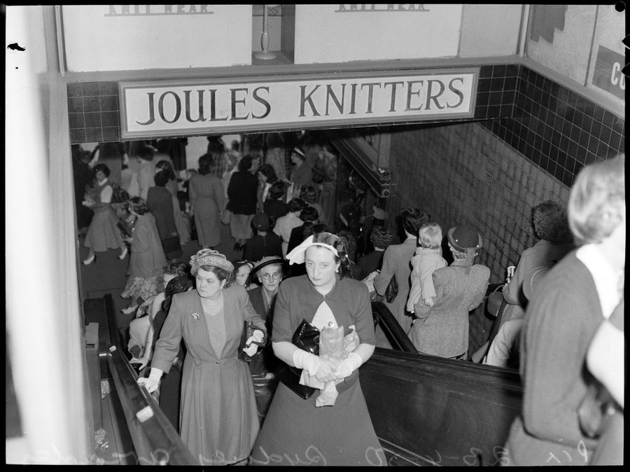 Shoppers descending beneath the Joules Knitters sign, Sydney arcade, 1950 — photograph, from null, circa 1950